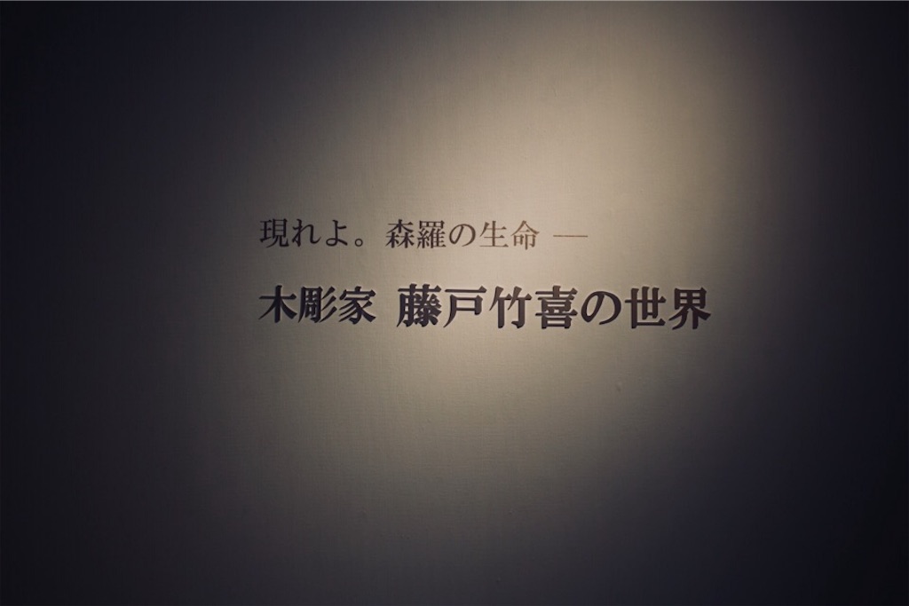 『現れよ。森羅の生命― 木彫家 藤戸竹喜の世界』と書かれた会場の入口